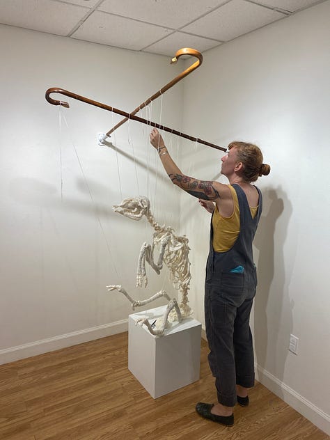 Installation views of a gallery with several artworks depicting sheep. All works are made of ceramic with fiber attachments connecting them together.