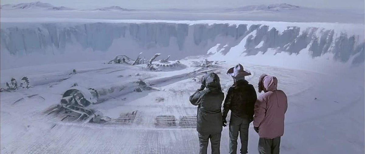 Three men look out at a crashed spacecraft somewhere in Antartica in John Carpenter's 1982 film The Thing.