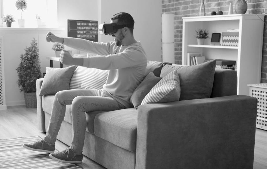 Man wearing vr headset playing a game on couch. Man wearing vr headset playing a game on couch.