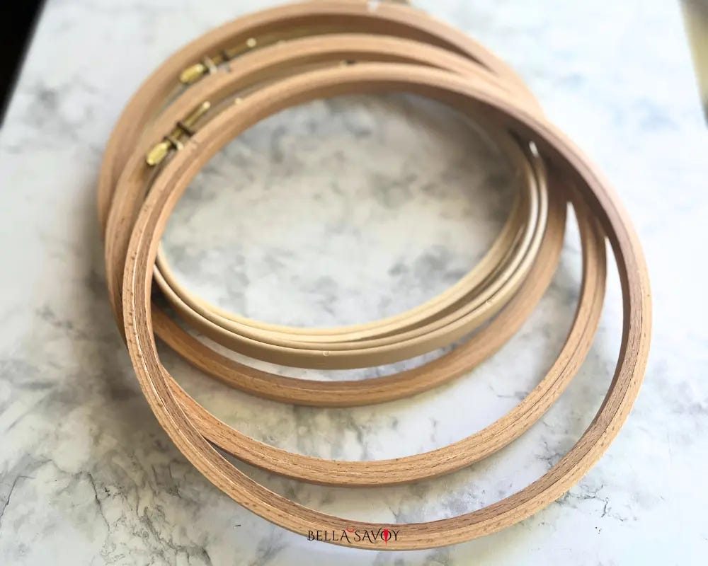 a small pile of embroidery hoops on marble surface