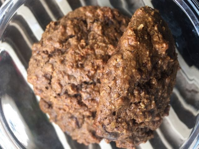 Two brown (looking), chunky cookies in a glass bowl Two brown (looking), chunky cookies in a glass bowl