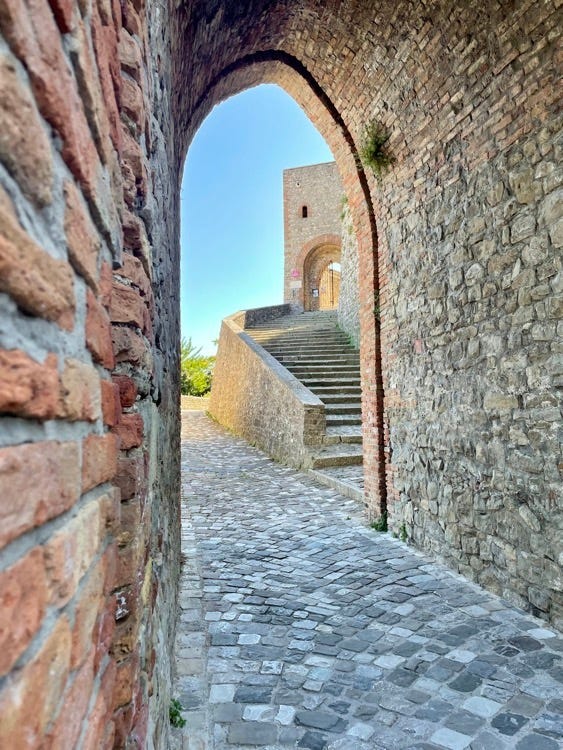 Vista della Rocca di Montefiore dal basso e ingresso al castello. Sotto la Rocca Malatestiana di Mondaino e l'ingresso alle fosse Malatestiane