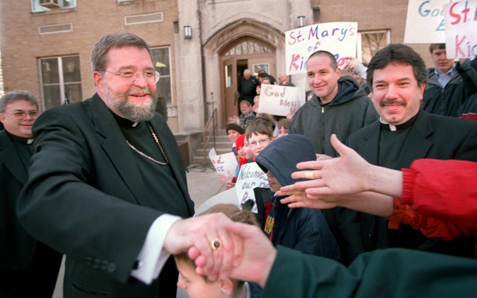 Newly-named Bishop of the Catholic Diocese of Peoria Daniel R. Jenky reaches for outstretched hands from the crowd as he is greeted at the Sheen Center in Peoria in 2002. [DAVID ZALAZNIK/JOURNAL STAR FILE PHOTO]