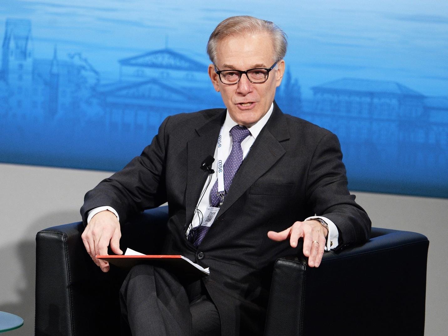 A person in a suit and tie sitting in a chair

AI-generated content may be incorrect.