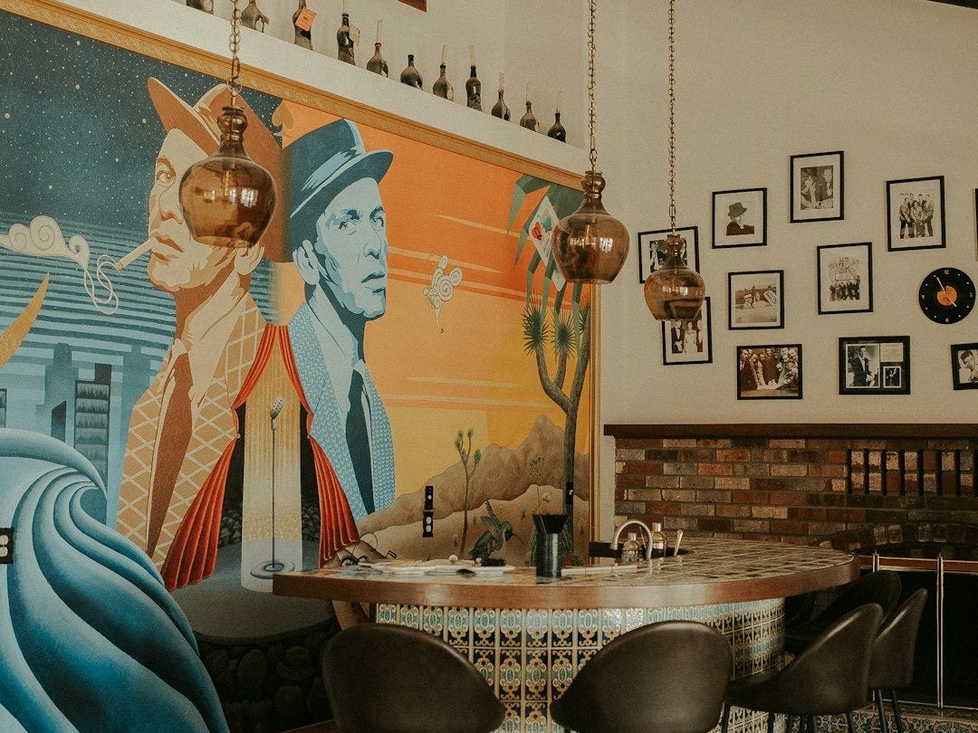 a dining room with a painting on the wall a dining room with a painting on the wall
