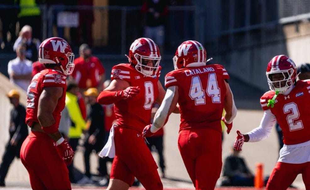 Wisconsin linebackers Mason Posa (8) and Cooper Catalano (44) celebrate with teammates on the field.