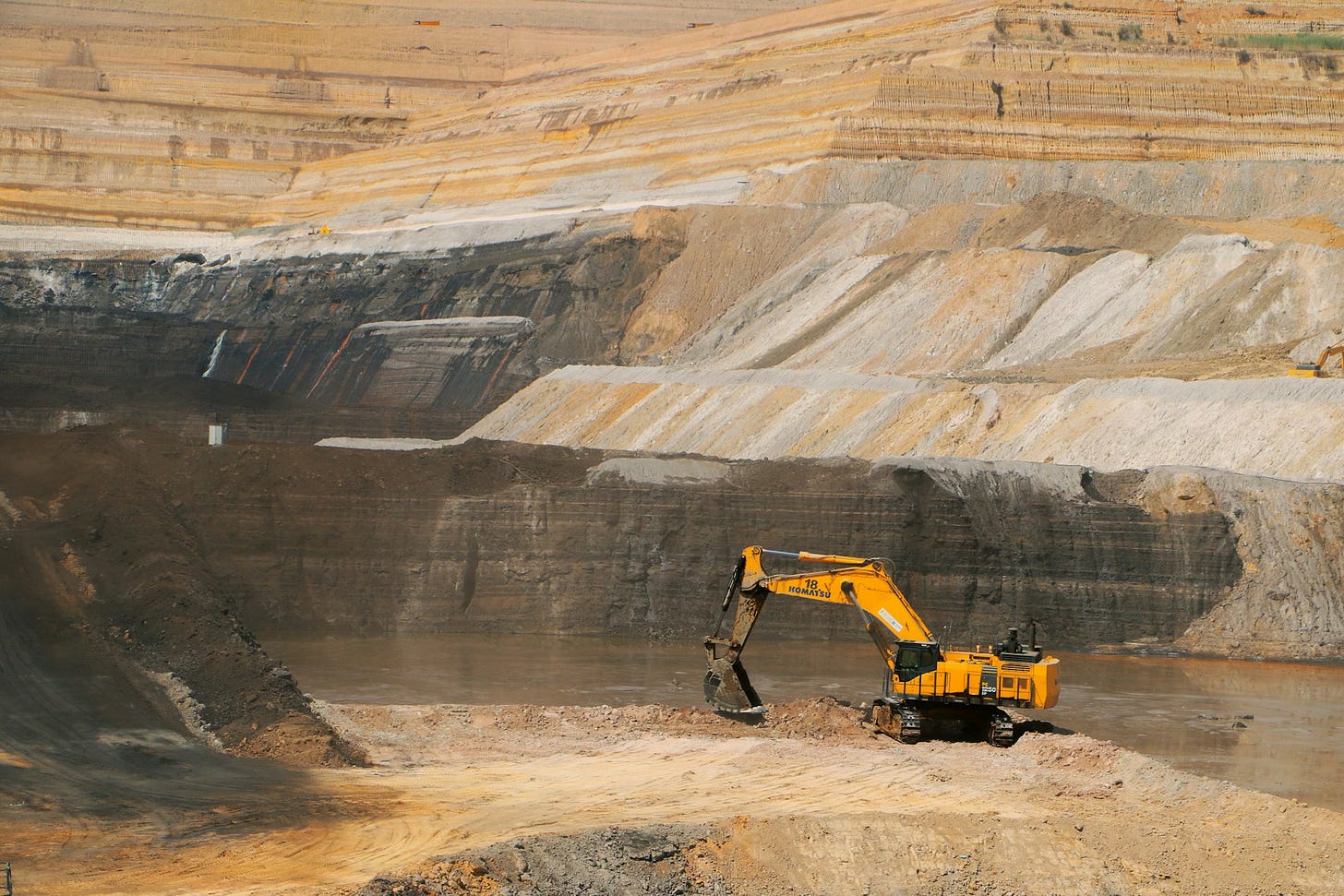 Fotografia em cores de escavadora amarela em sítio de mineração. Fotografia em cores de escavadora amarela em sítio de mineração.
