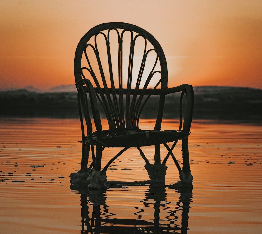 silhouette of wooden chair on beach during sunset silhouette of wooden chair on beach during sunset