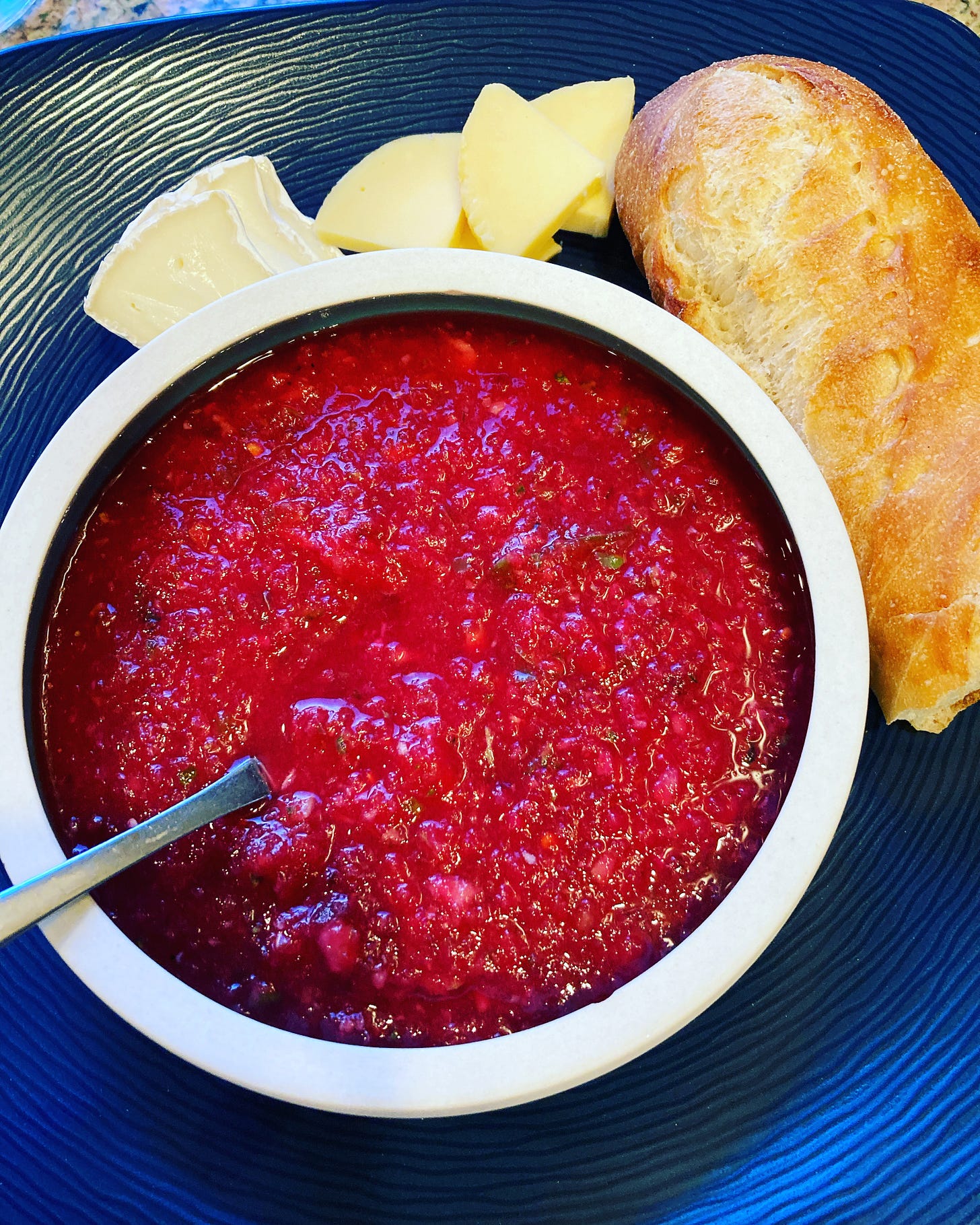 Pinkish red gazpacho with bread and cheese