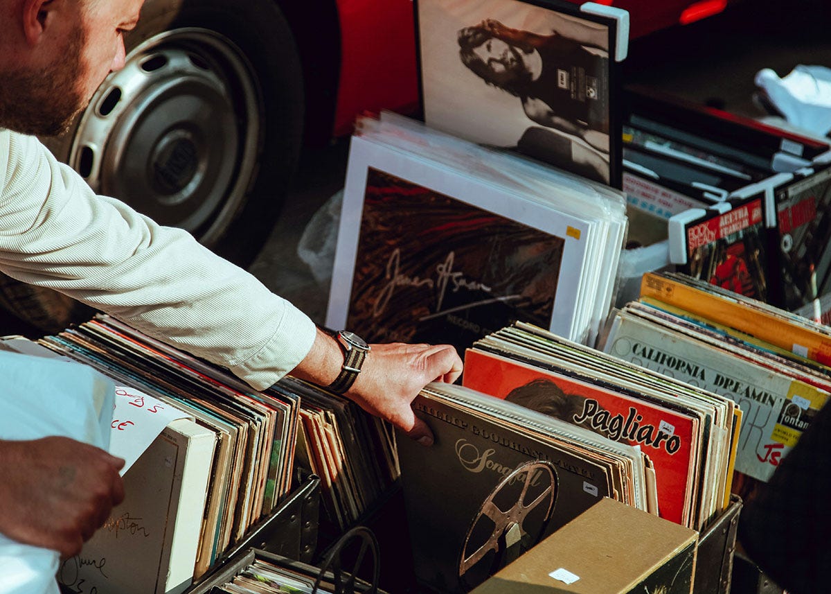 Man looking through a box of old records at a boot sale