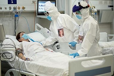 Dua dokter sedang mendampingi pasien yang terbaring.