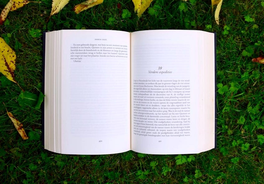 opened book on grass during daytime