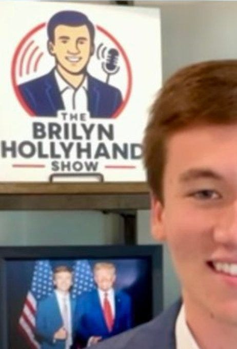 A logo with a cartoon illustration of Brilyn Hollyhand, depicted as a man in a suit with dark hair, smiling, surrounded by sound wave graphics and a microphone. Below the illustration, the text reads "The Brilyn Hollyhand Show" in bold letters. In the background, a television screen displays two men in suits, one in blue and one in red, standing in front of an American flag. A person with brown hair and a suit is partially visible in the foreground, smiling.