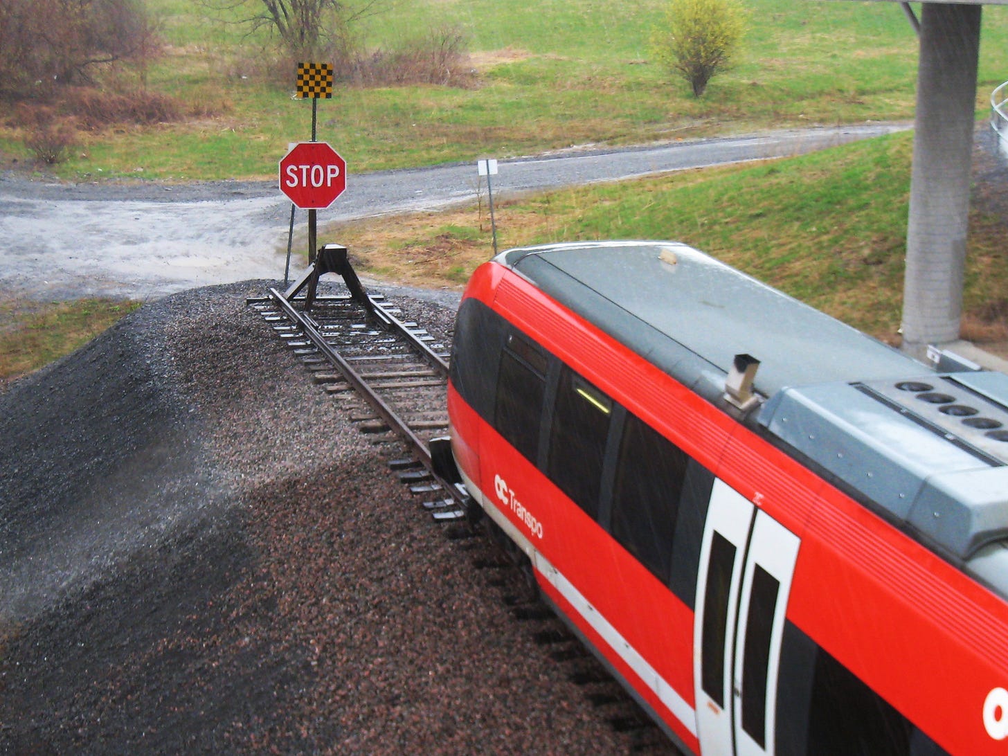 A train at the end of a track, with a stop sign in front of it. A train at the end of a track, with a stop sign in front of it.