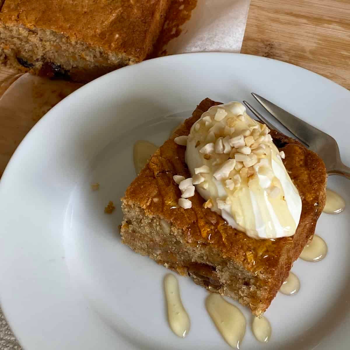 Slice of Carrot Cake Traybake topped with yogurt, honey and nuts. Slice of Carrot Cake Traybake topped with yogurt, honey and nuts.