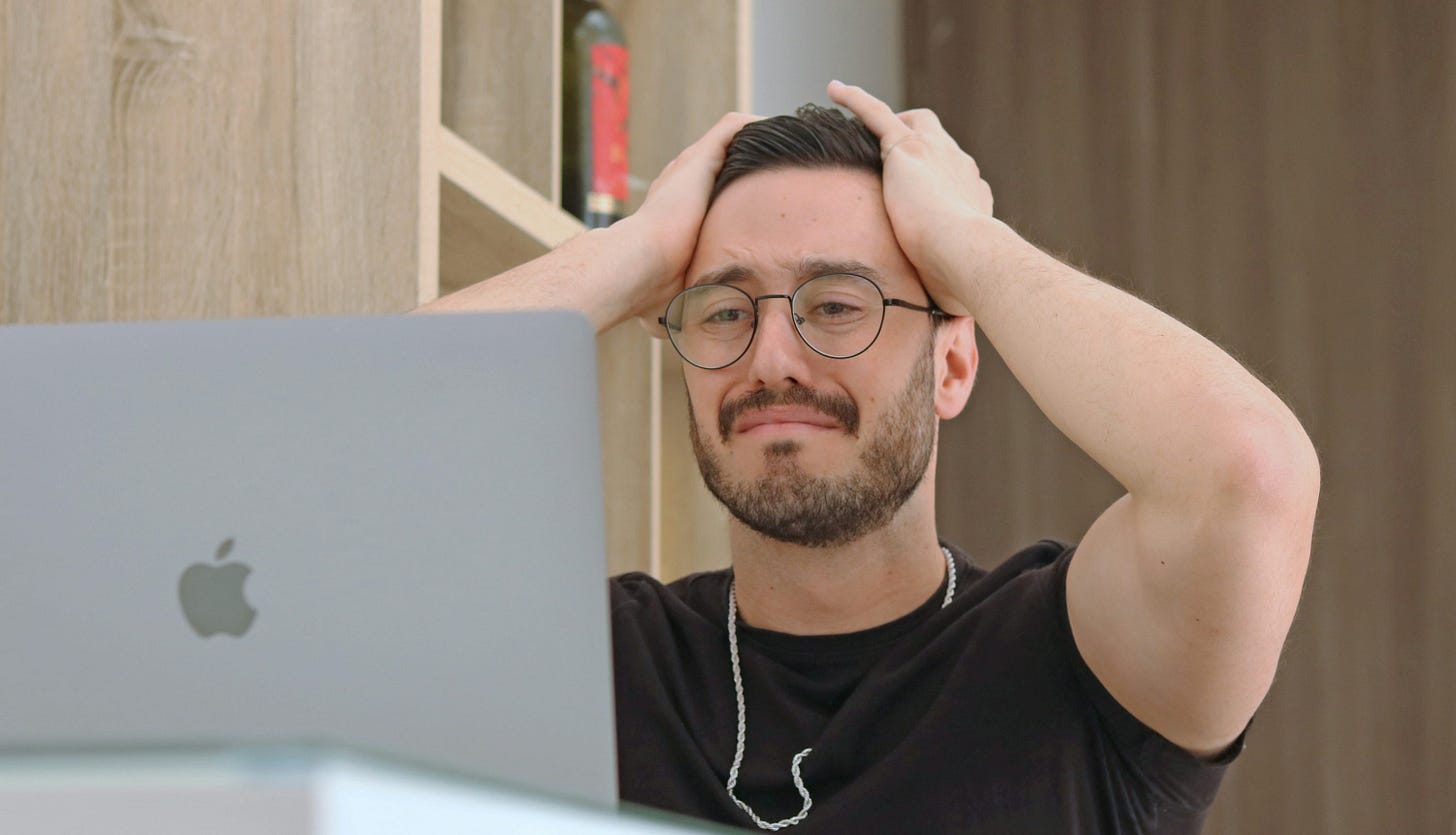 a man with glasses is looking at a laptop a man with glasses is looking at a laptop
