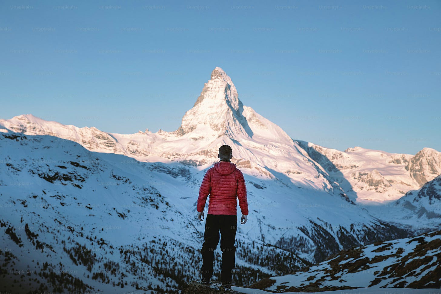 a man standing on top of a snow covered mountain