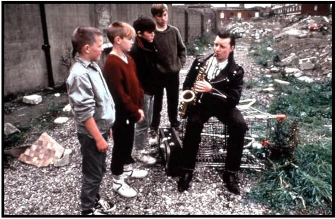 In the movie, "The Commitments," Dean practices his saxophone outside as a group of boys listen to him.