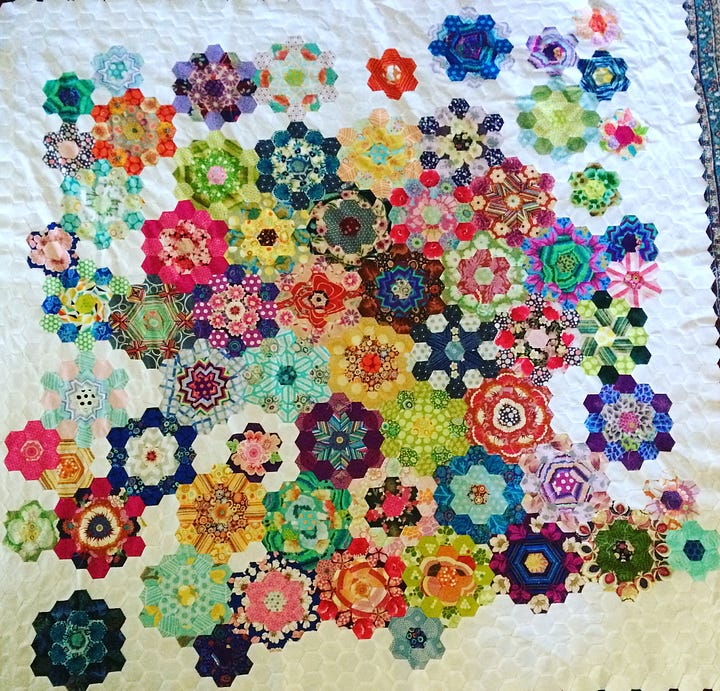 two different quilts made with hexagon shaped pieces, one on the left is flowers and the other on the right is patterned differently to show bars