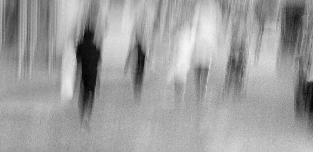 a group of people walking down a street a group of people walking down a street