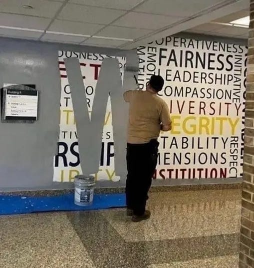 Man painting grey paint to cover words on the wall at the FBI, words includ respect, initiative, diversity.