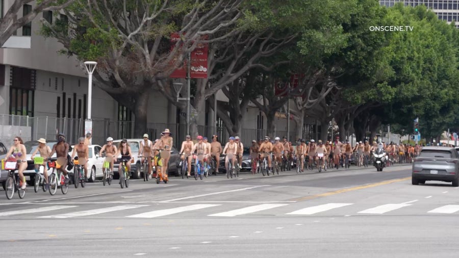 Nude and partially clothed cyclists ride together through downtown Los Angeles. Nude and partially clothed cyclists ride together through downtown Los Angeles.