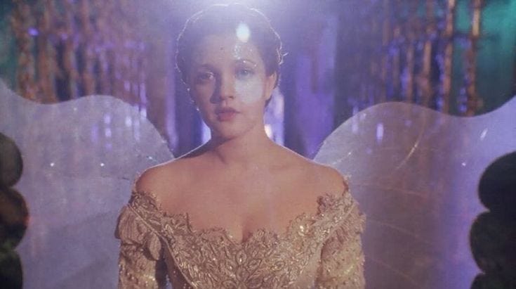 This may contain: a woman in a gold dress with angel wings This may contain: a woman in a gold dress with angel wings