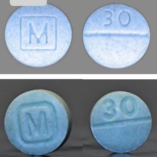 Blue counterfeit containing fentanyl are pictured alongside the real oxycodone pills. Both look very similar in color, with an M stamped on one side and 30 stamped on the other. Blue counterfeit containing fentanyl are pictured alongside the real oxycodone pills. Both look very similar in color, with an M stamped on one side and 30 stamped on the other.