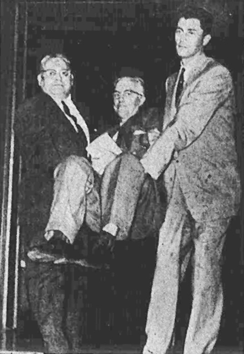 Image of a white man, Rev Maurice McCracken being carried into court for resisting war taxes in 1958. He is wearing a suit and so are the men who are carrying him into court. Image of a white man, Rev Maurice McCracken being carried into court for resisting war taxes in 1958. He is wearing a suit and so are the men who are carrying him into court.