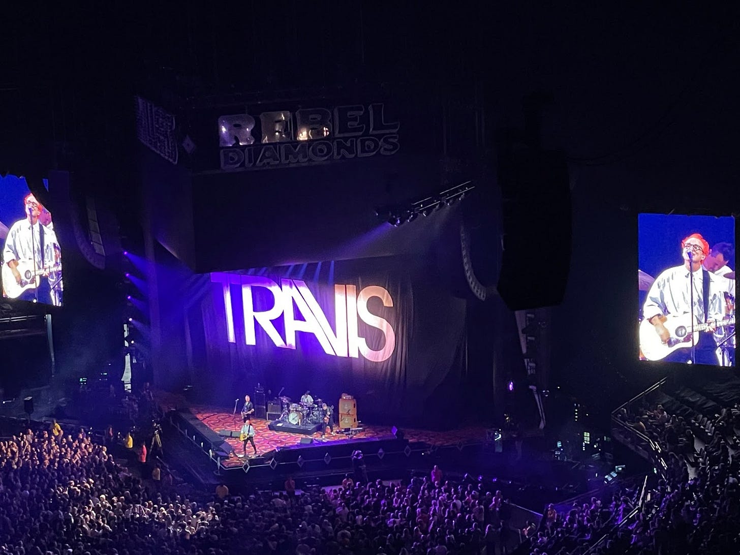 Travis performs on a triangular stage in the O2 arena in London. Travis performs on a triangular stage in the O2 arena in London.