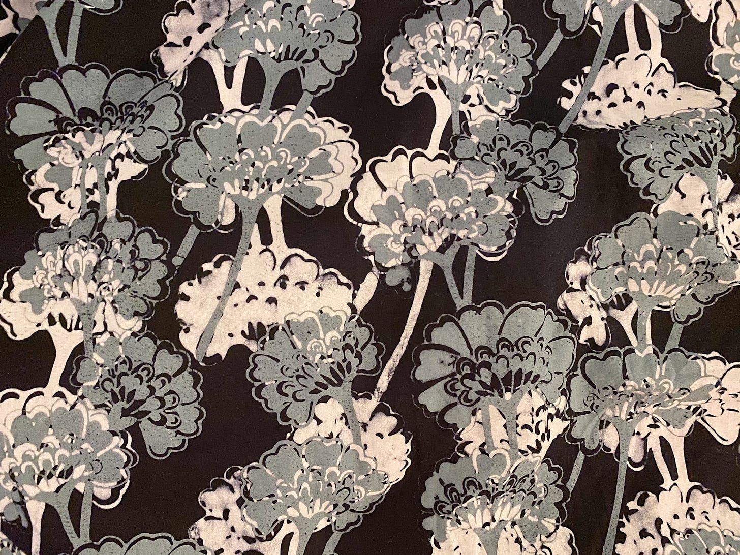 malaysian batik print with stylized ginkgo leaves in gray and white on a black background