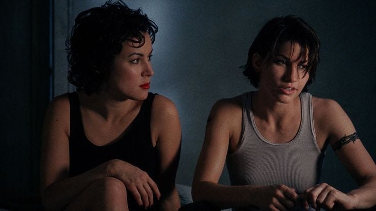 This may contain: two women sitting on a bed in the dark