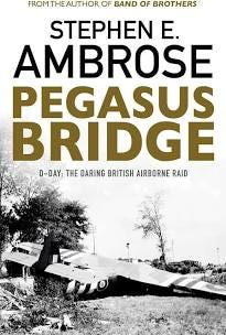 A black and white photo or illustration of British gliders crash landed dominates the cover. The title “Pegasus Bridge” appears in bold gold block letter mid cover, with the author's name in black block letters above the title.  