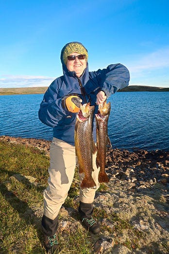 Guðrún með urriðana sína tvo.
Guðrún með urriðana sína tvo.