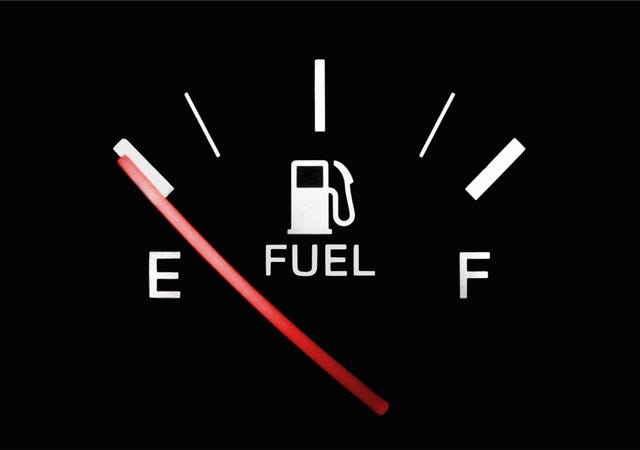 A black fuel tank gauge with the red needle pointing to E A black fuel tank gauge with the red needle pointing to E