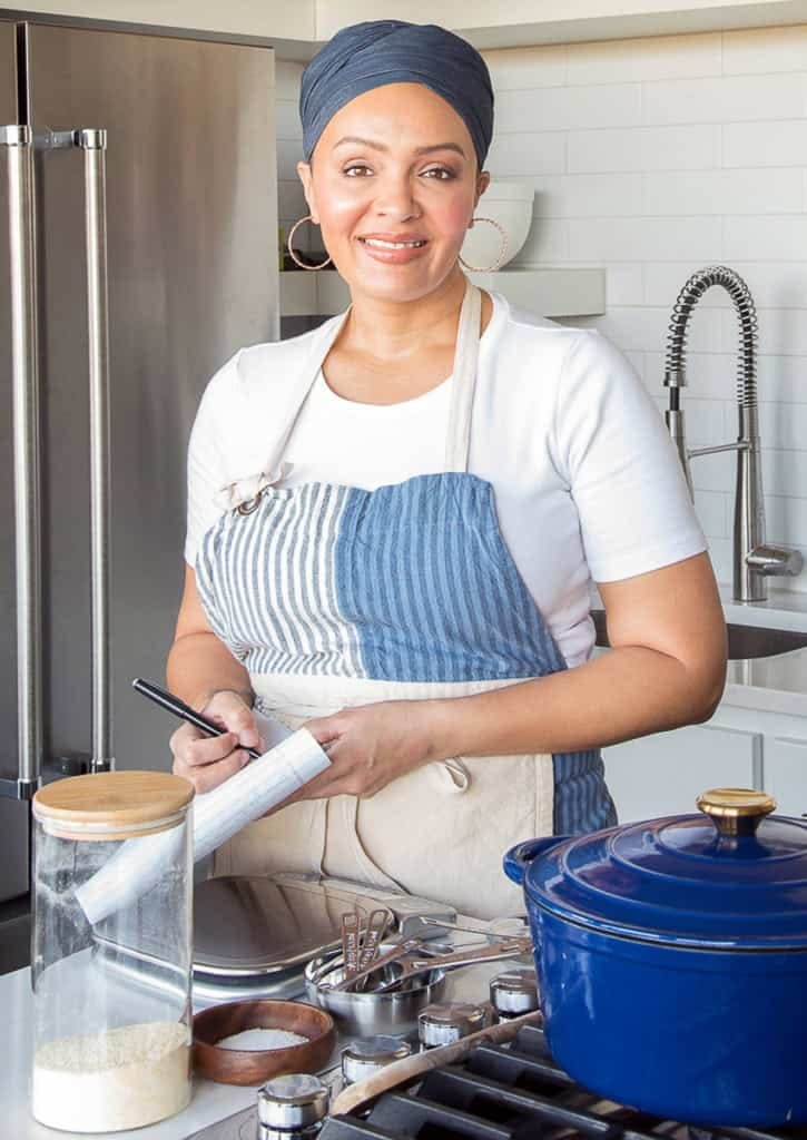 Marta standing at a stove with a notepad and pen in her hand. Marta standing at a stove with a notepad and pen in her hand.