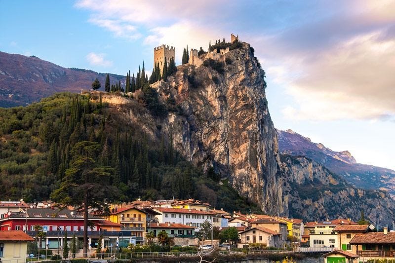 A panoramic view of Arco and the Lake Garda region in northern Italy, featuring dramatic cliffs, mountains and the lake's shoreline. A panoramic view of Arco and the Lake Garda region in northern Italy, featuring dramatic cliffs, mountains and the lake's shoreline.