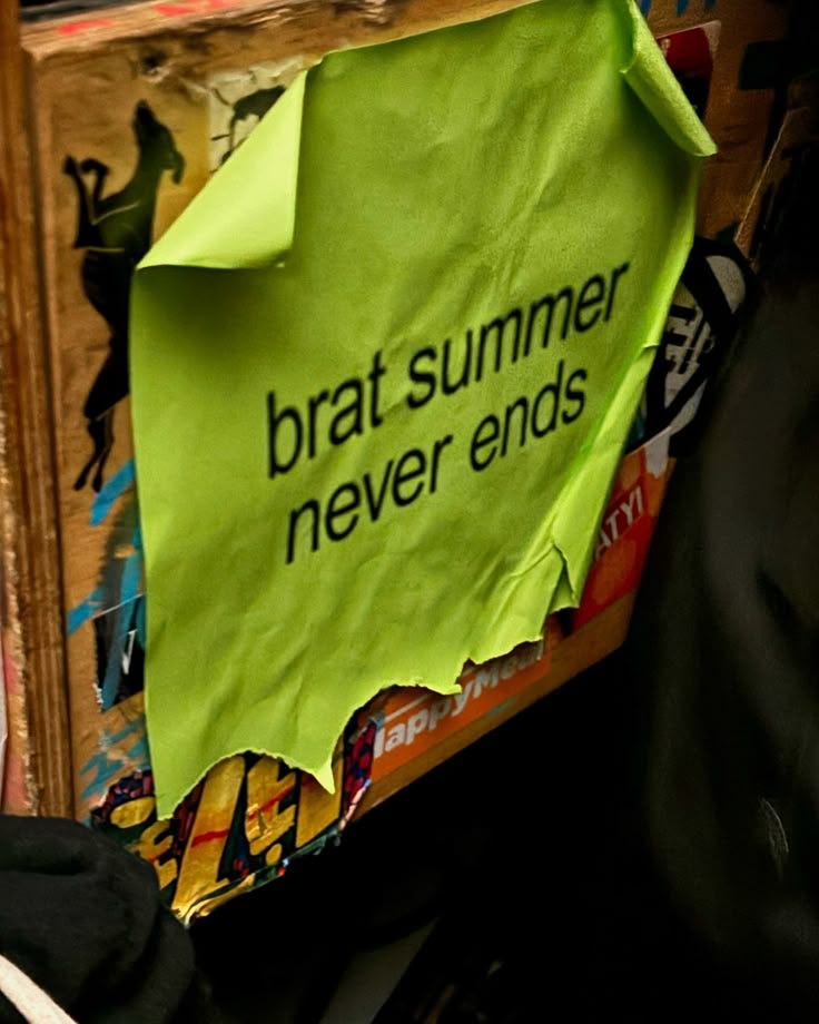 This may contain: a green paper sign that says brat summer never ends