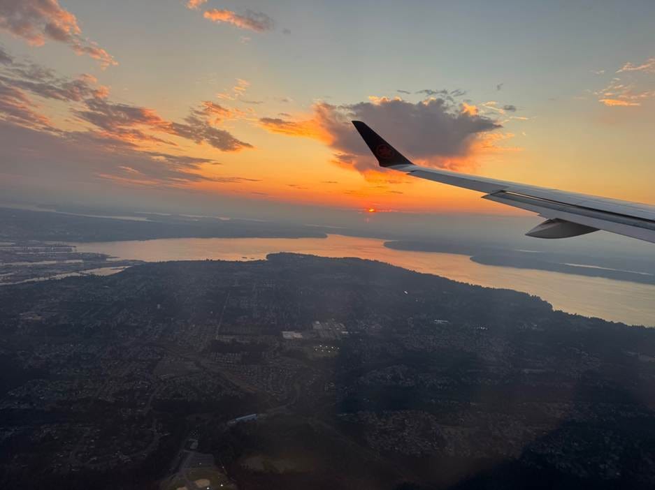 An airplane wing and land with water and a sunset

AI-generated content may be incorrect.