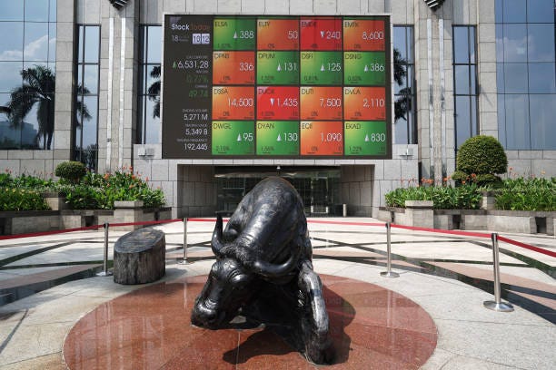 Statue of a bull stands in front of an electronic board displaying stock prices outside the Indonesia Stock Exchange in Jakarta, Indonesia, on...