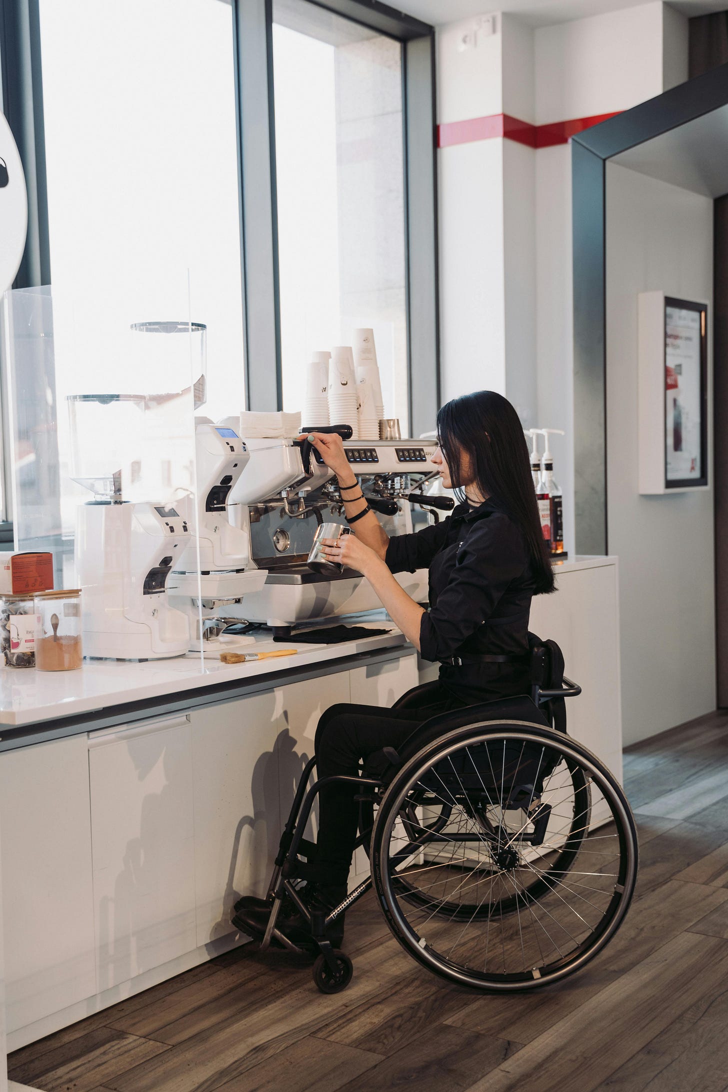 Wheelchair user who uses a coffee machine in an office