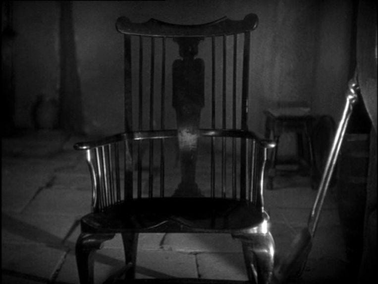 A chair in a dark room

Description automatically generated