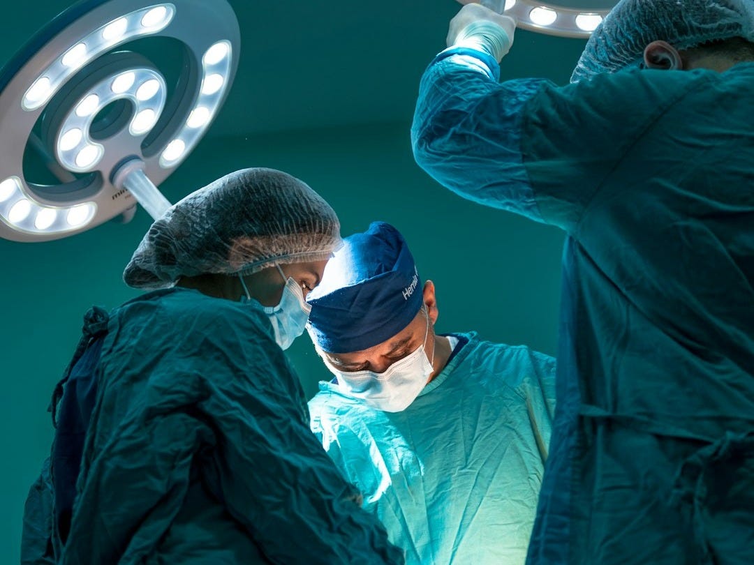 a group of doctors performing surgery on a patient a group of doctors performing surgery on a patient