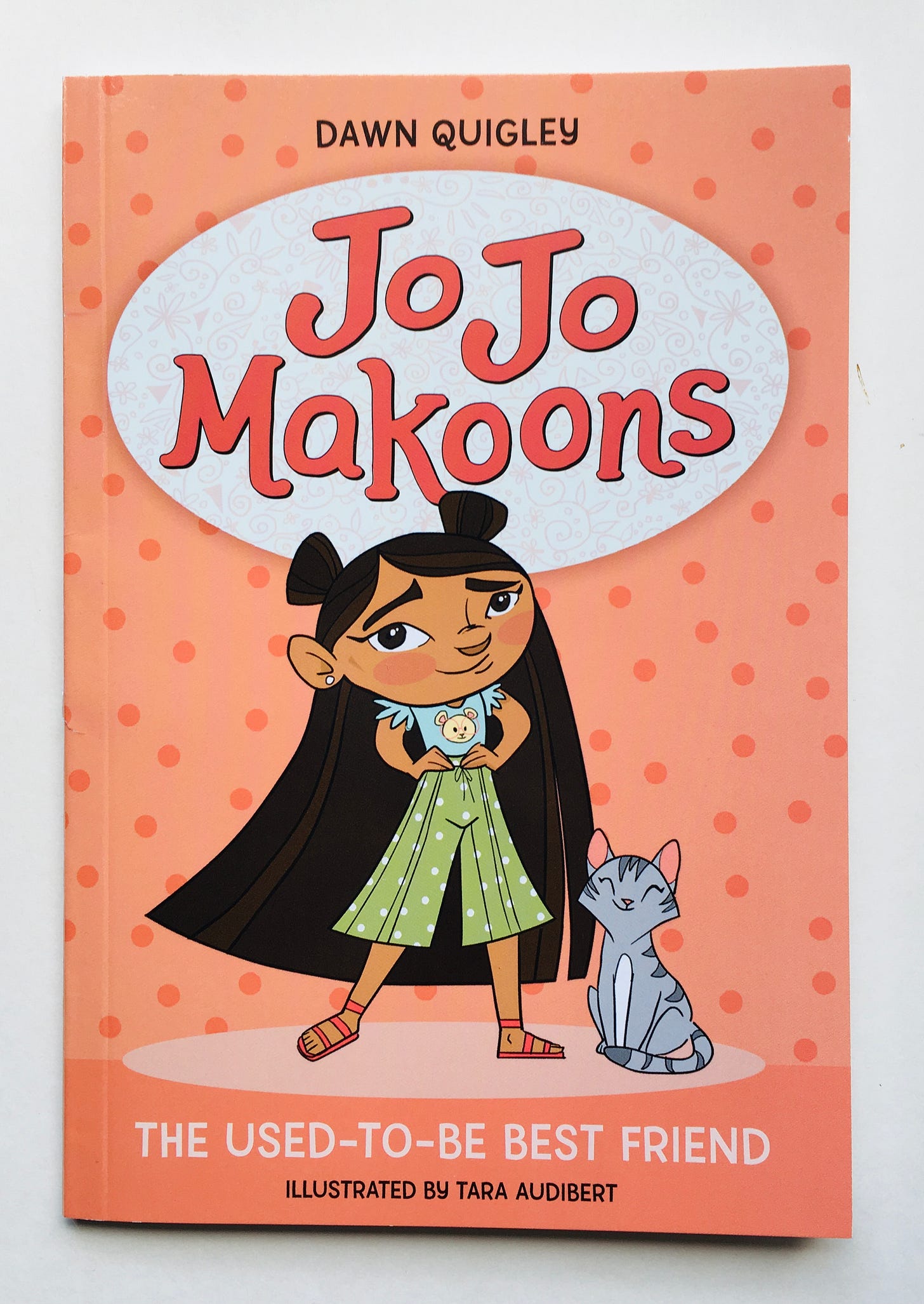A young girl with long dark hair stands with her hands on her hips