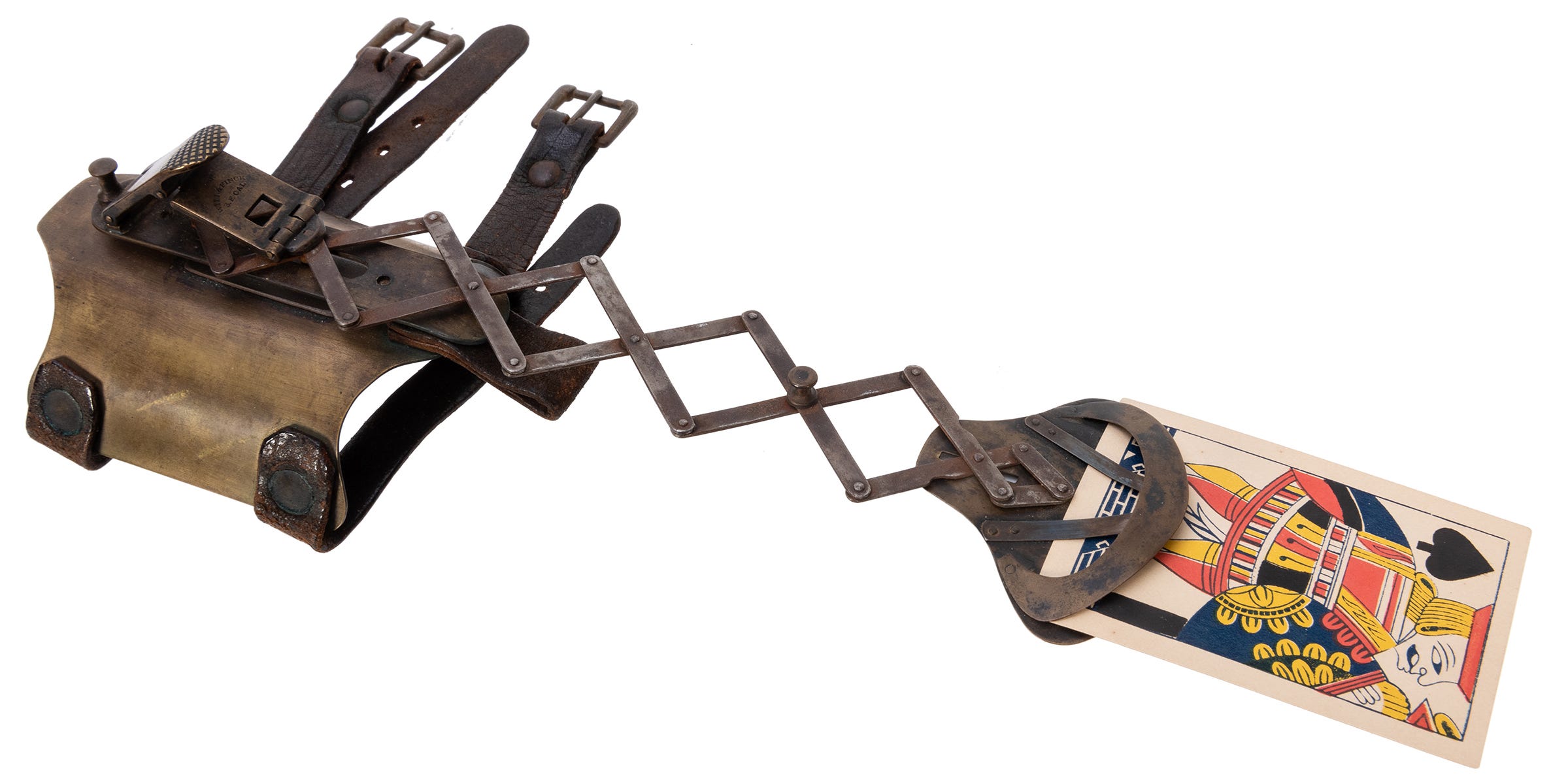 A brass contraption with an extendable arm holding a playing card. A brass contraption with an extendable arm holding a playing card.