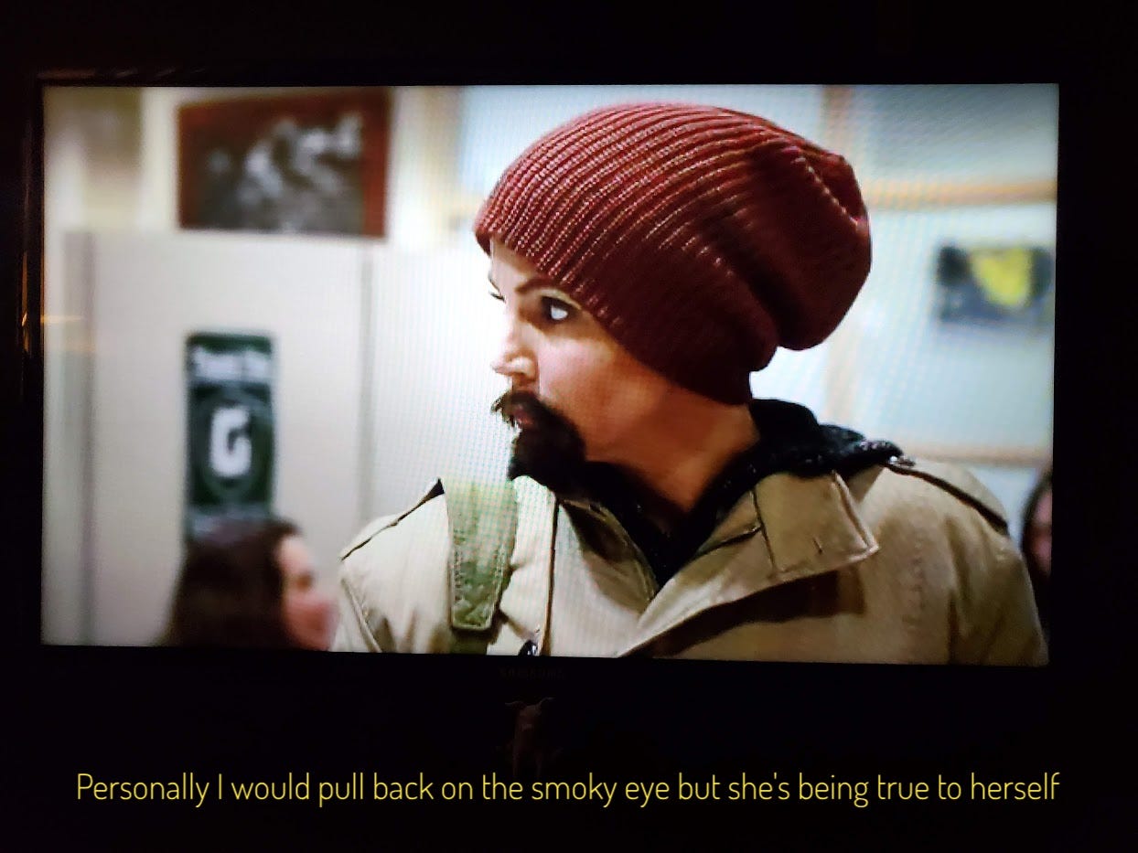 Anne, in her beanie and fake beard, captioned "Personally I would pull back on the smoky eye but she's being true to herself"