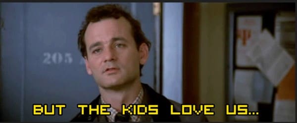 Film still of a weary-looking man in a dark jacket, with yellow subtitle text reading, “BUT THE KIDS LOVE US…”