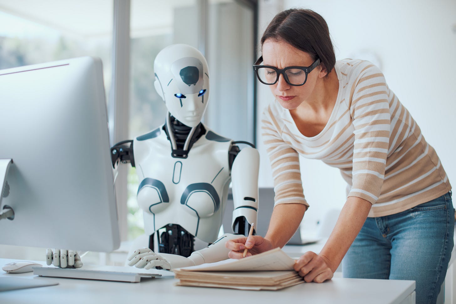 Woman and AI robot working together By StockPhotoPro
