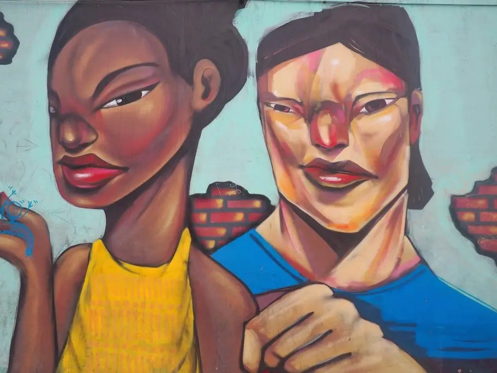 Street art - two people with angular faces, one dressed in yellow, the other in blue