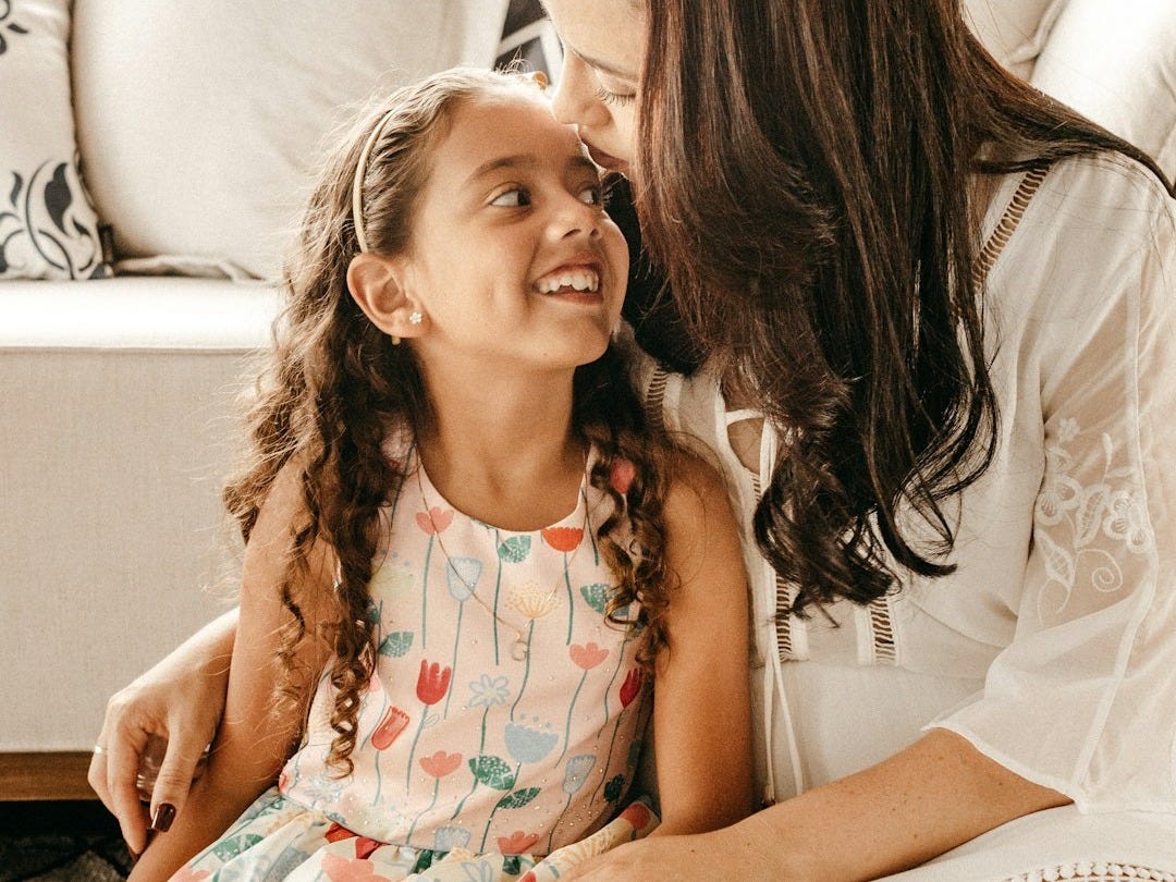 a woman sitting on the floor with a little girl a woman sitting on the floor with a little girl